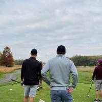Three alumni playing golf